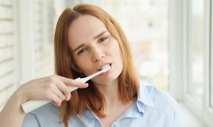 Esclerosis múltiple y salud bucodental: mujer cepillándose dientes