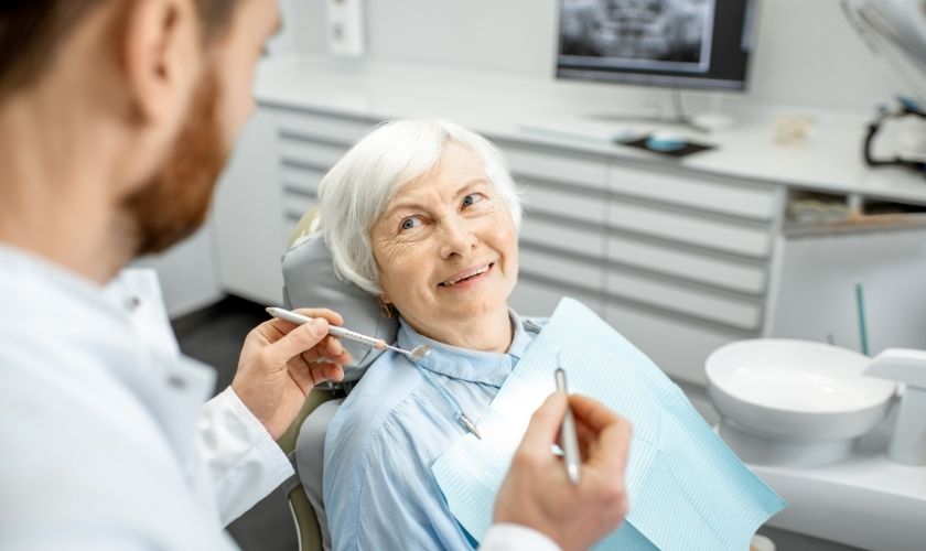 Consejos de salud oral para ayudar a personas con Alzheimer: mujer mayor en consulta de dentista.