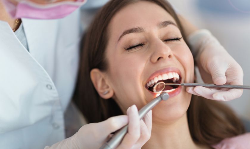 Calendario de higiene oral para personas con diabetes: dentista revisando las encías de una paciente.
