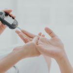 Diabetes y periodontitis: doctor midiendo la glucosa capilar con un glucómetro