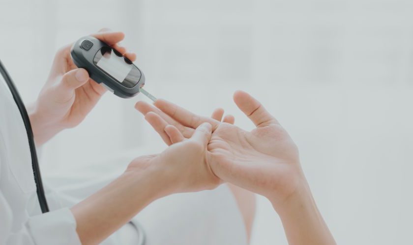 Diabetes y periodontitis: doctor midiendo la glucosa capilar con un glucómetro